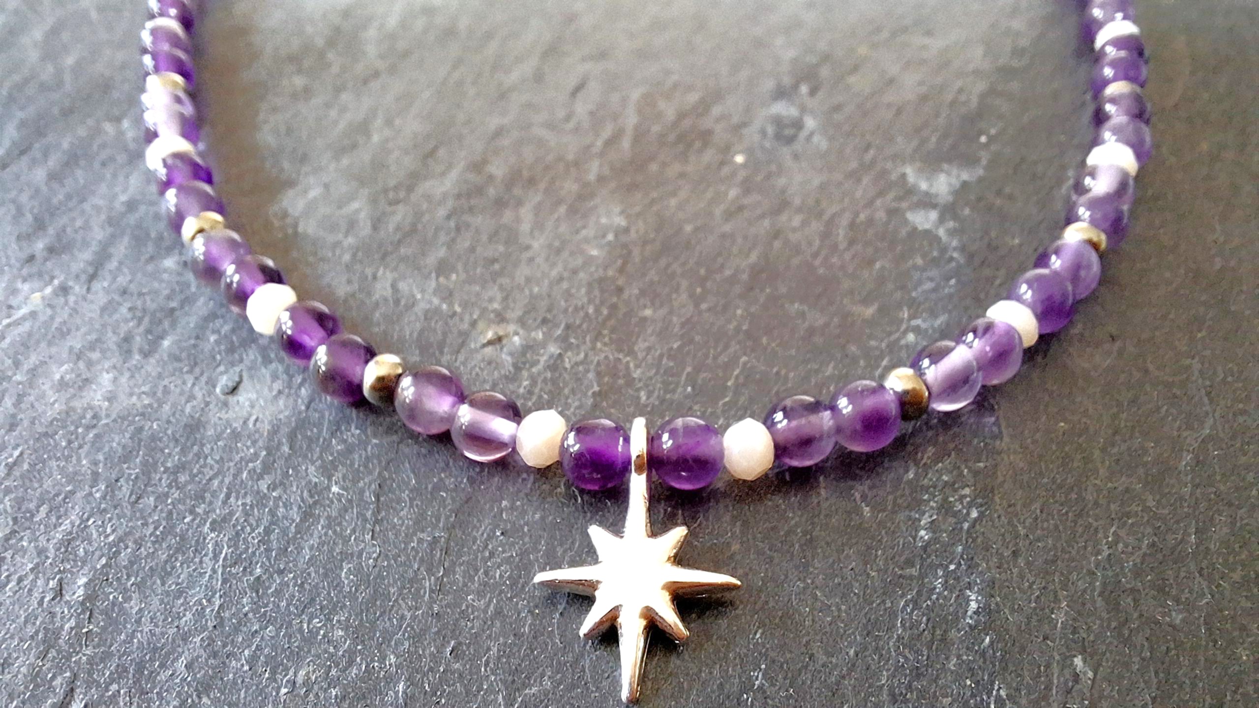 Collier Améthyste et étoile du Nord argentée. SAGESSE & HUMILITE. AMETHYSTE. Elle est la pierre de la sagesse et de l’humilité. Cette pierre d’un violet profond : Développe la volonté et la motivation. Aide à la concentration, à l’harmonie. Favorise la perception consciente et l’assimilation des expériences. Aide à la méditation. Elimine les cauchemars et éclaircit les rêves. Apporte paix et détente. Aide au dépassement du deuil et de la perte. Développe le sens de la justice. Agit contre l’angoisse, le stress, l’insomnie et diverses addictions. Lutte contre les excès obsessionnels d’ordre sexuel. Calme les maux de tête et est excellente pour les poumons, la peau et le foie. Aide à la résorption des brûlures. Détend les muscles.