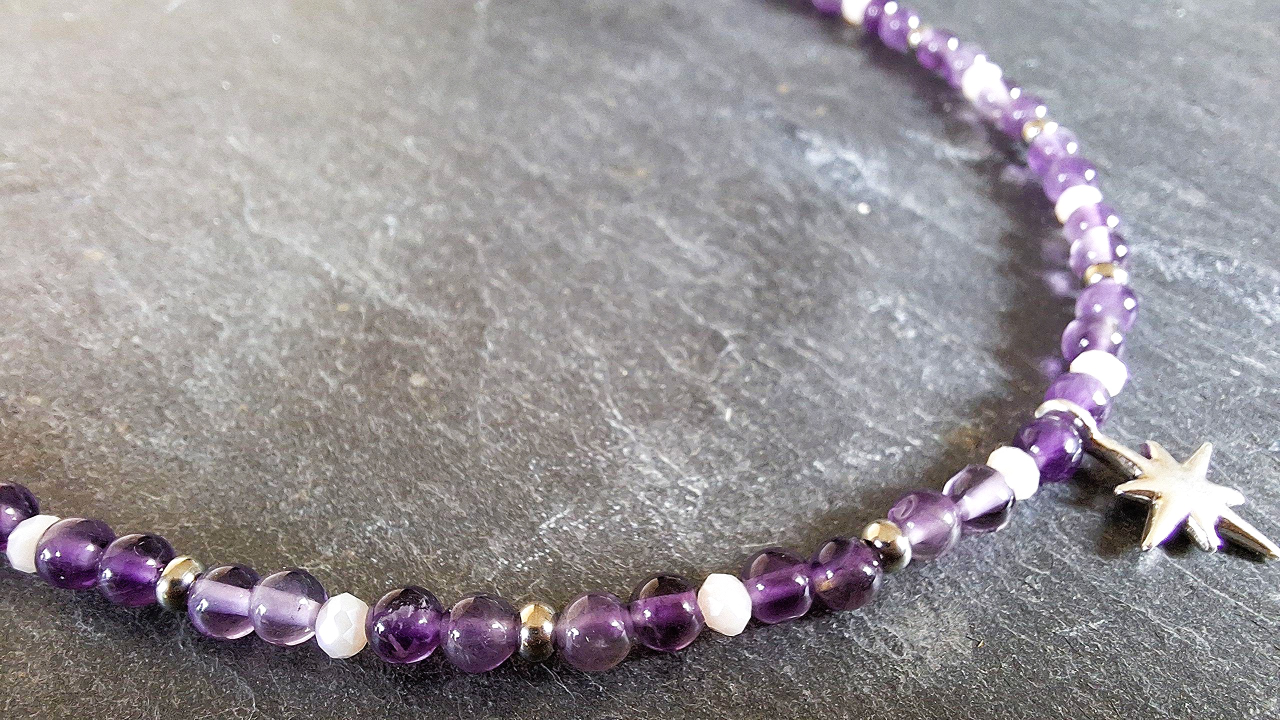 Collier Améthyste et étoile du Nord argentée. SAGESSE & HUMILITE. AMETHYSTE. Elle est la pierre de la sagesse et de l’humilité. Cette pierre d’un violet profond : Développe la volonté et la motivation. Aide à la concentration, à l’harmonie. Favorise la perception consciente et l’assimilation des expériences. Aide à la méditation. Elimine les cauchemars et éclaircit les rêves. Apporte paix et détente. Aide au dépassement du deuil et de la perte. Développe le sens de la justice. Agit contre l’angoisse, le stress, l’insomnie et diverses addictions. Lutte contre les excès obsessionnels d’ordre sexuel. Calme les maux de tête et est excellente pour les poumons, la peau et le foie. Aide à la résorption des brûlures. Détend les muscles.