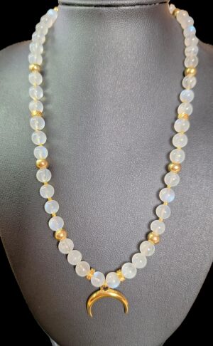Collier Pierre de Lune & Croissant de Lune doré. Elle est la pierre de la Féminité, de la confiance en soi et de la séduction. Cette pierre dite « d’Aphrodite » fortement YIN : Stimule l’imagination. Apporte poésie, douceur, sensibilité, calme, tolérance, équilibre et confiance en soi. Ouvre à l’inspiration et à l’impulsion. Procure de la profondeur aux sentiments. Contribue au bonheur conjugal. Compense les tendances trop matérialistes, terre à terre. Développe l’intuition et favorise l’ouverture d’esprit. Permet les rêves prémonitoires. Humanise l’acte sexuel (vs procréation). Met en harmonie les cycles hormonaux, aides en cas de troubles menstruels, après un accouchement et lors de la ménopause. Aide à la fertilité.