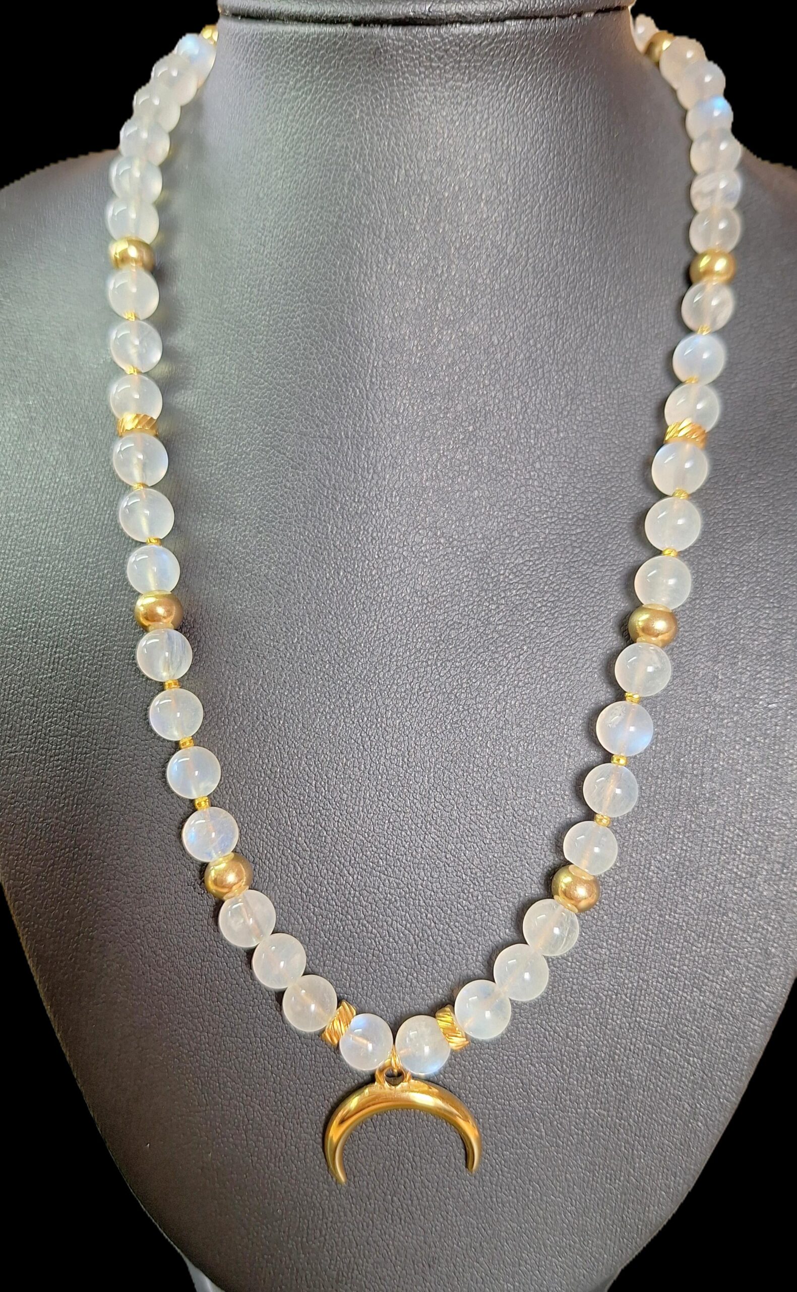 Collier Pierre de Lune & Croissant de Lune doré. Elle est la pierre de la Féminité, de la confiance en soi et de la séduction. Cette pierre dite « d’Aphrodite » fortement YIN : Stimule l’imagination. Apporte poésie, douceur, sensibilité, calme, tolérance, équilibre et confiance en soi. Ouvre à l’inspiration et à l’impulsion. Procure de la profondeur aux sentiments. Contribue au bonheur conjugal. Compense les tendances trop matérialistes, terre à terre. Développe l’intuition et favorise l’ouverture d’esprit. Permet les rêves prémonitoires. Humanise l’acte sexuel (vs procréation). Met en harmonie les cycles hormonaux, aides en cas de troubles menstruels, après un accouchement et lors de la ménopause. Aide à la fertilité.