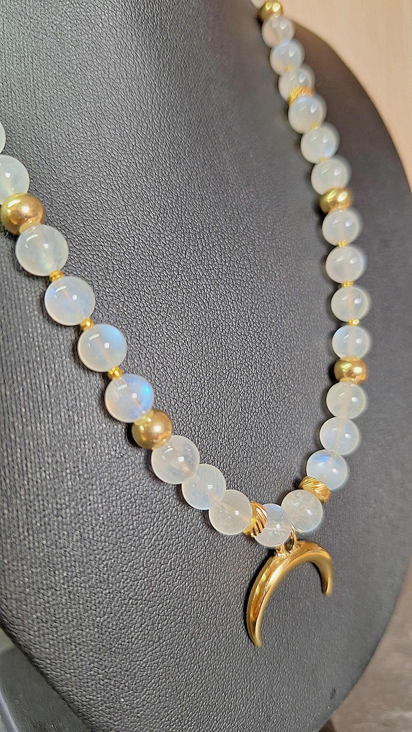 Collier Pierre de Lune & Croissant de Lune doré. Elle est la pierre de la Féminité, de la confiance en soi et de la séduction. Cette pierre dite « d’Aphrodite » fortement YIN : Stimule l’imagination. Apporte poésie, douceur, sensibilité, calme, tolérance, équilibre et confiance en soi. Ouvre à l’inspiration et à l’impulsion. Procure de la profondeur aux sentiments. Contribue au bonheur conjugal. Compense les tendances trop matérialistes, terre à terre. Développe l’intuition et favorise l’ouverture d’esprit. Permet les rêves prémonitoires. Humanise l’acte sexuel (vs procréation). Met en harmonie les cycles hormonaux, aides en cas de troubles menstruels, après un accouchement et lors de la ménopause. Aide à la fertilité.